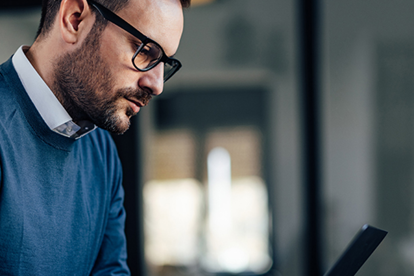 Steele Portrait 2 man in glasses working on laptop